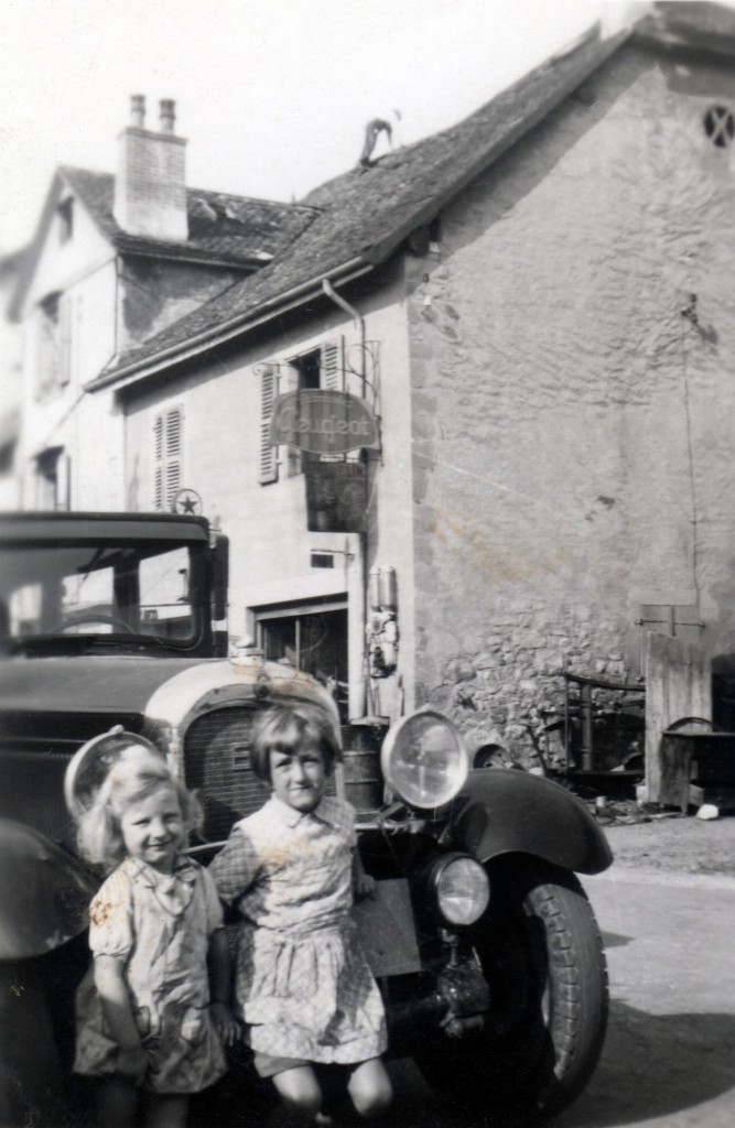 Le garage Dunand en 1948, au 11 rue de Versoix. A l'angle de la maison, on distingue le fût d'essence, vendue à la pompe à main, 5 litres à la fois. Agence Peugeot (panneau) mais la voiture est une des deux Citroen C6 d'Antonin Dunand. Celle-ci date de 1928 et, après suppression de la carroserie arrière, deviendra une dépanneuse équipée d'une "chèvre" de levage. Au premier plan, Roland (1944) et Gabriel "Gaby" (1942) Dunand. (GBY005, archives Gabriel Dunand)